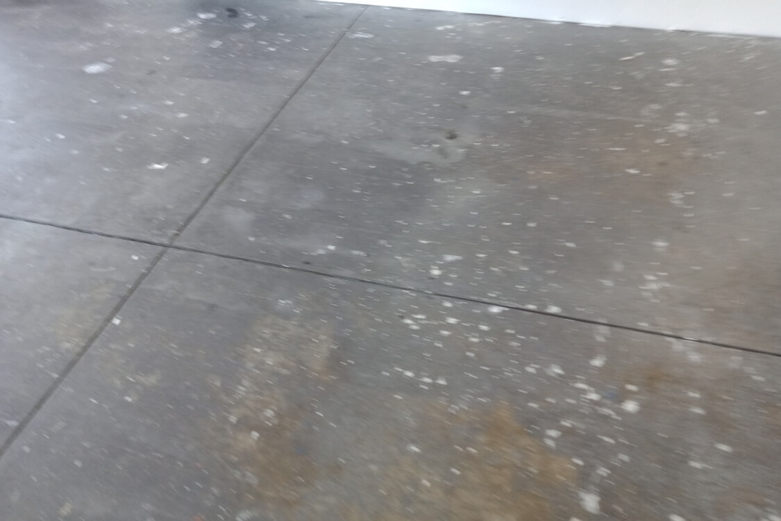 Dirty garage floor before being cleaned