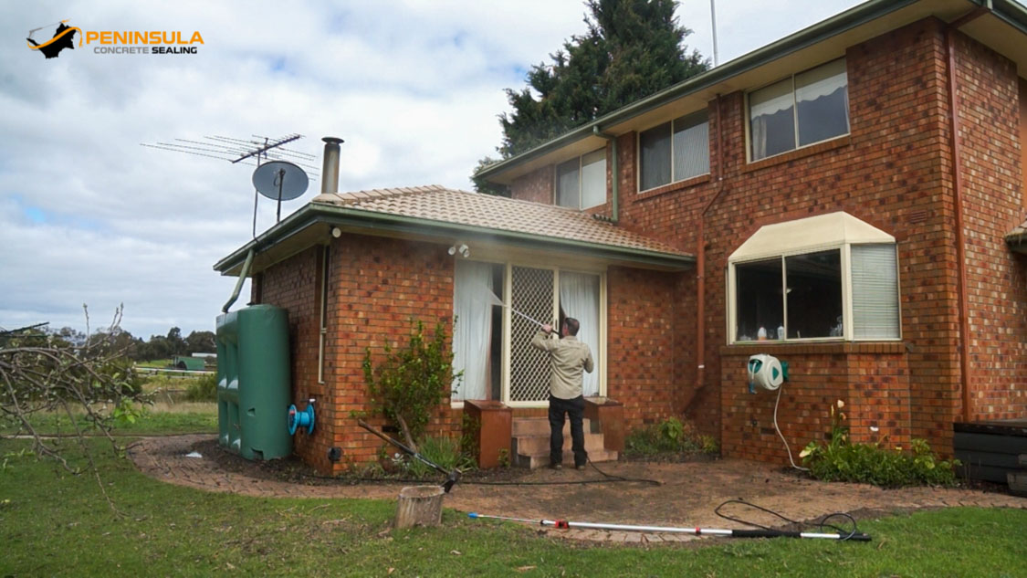 A brick house being cleaned by Peninsula pressure cleaning services