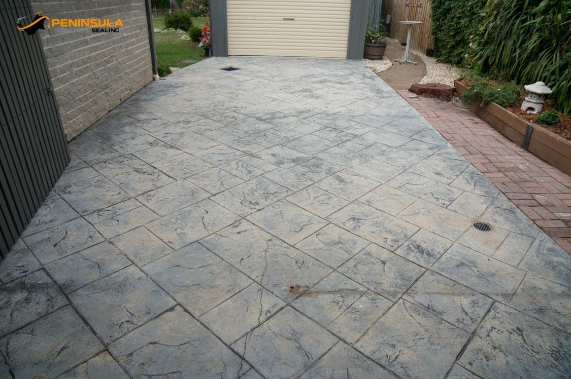 Worn stamped concrete driveway before restoration